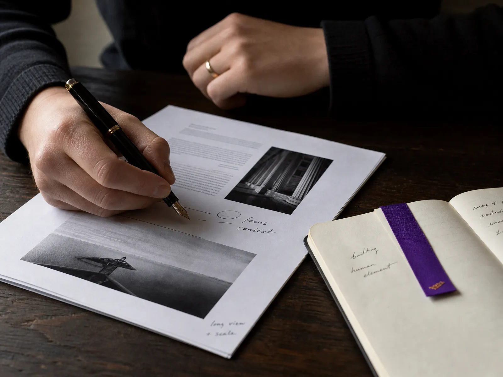 A notebook and pen beside a printed report on a dark wood desk, annotated by hand, used to show reviewing AI in SEO output.