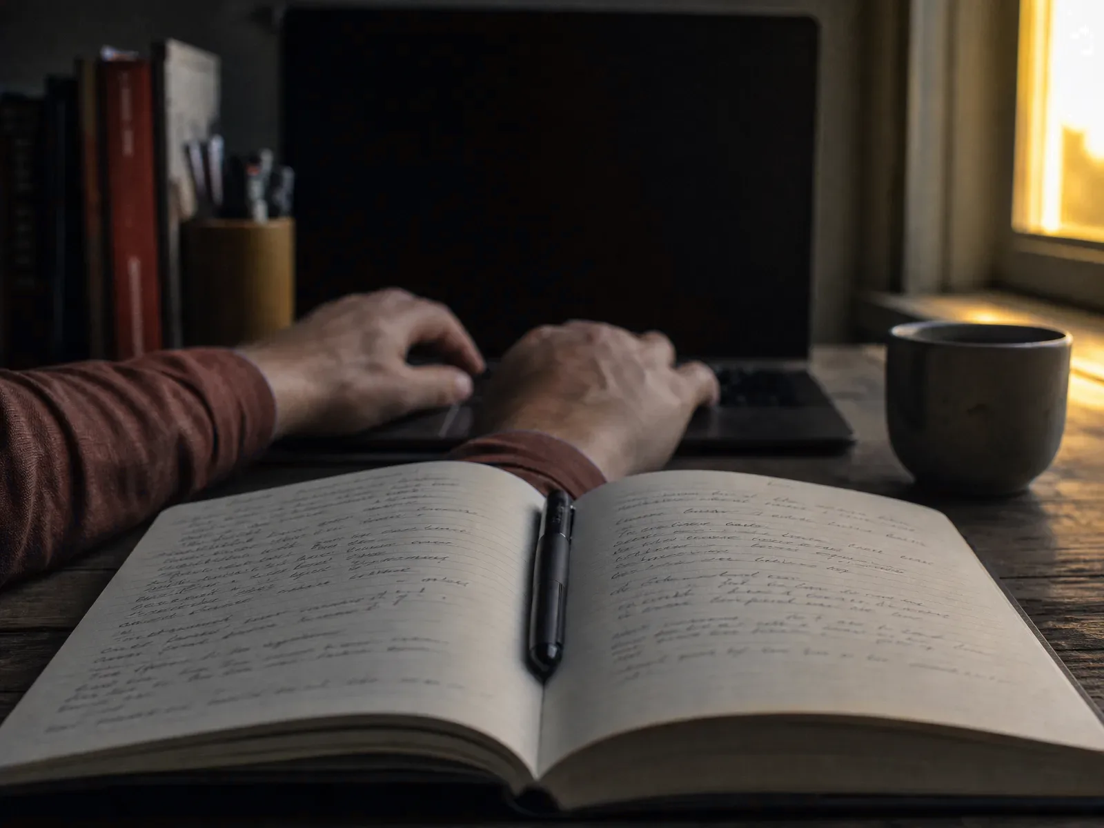 An open notebook with faint handwriting on a wooden desk