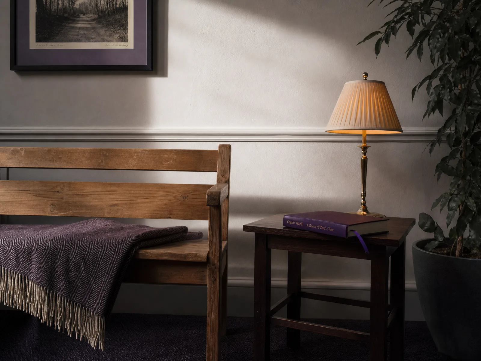 A calm UK reception waiting-area with wooden bench, brass lamp, and a violet-spined book.
