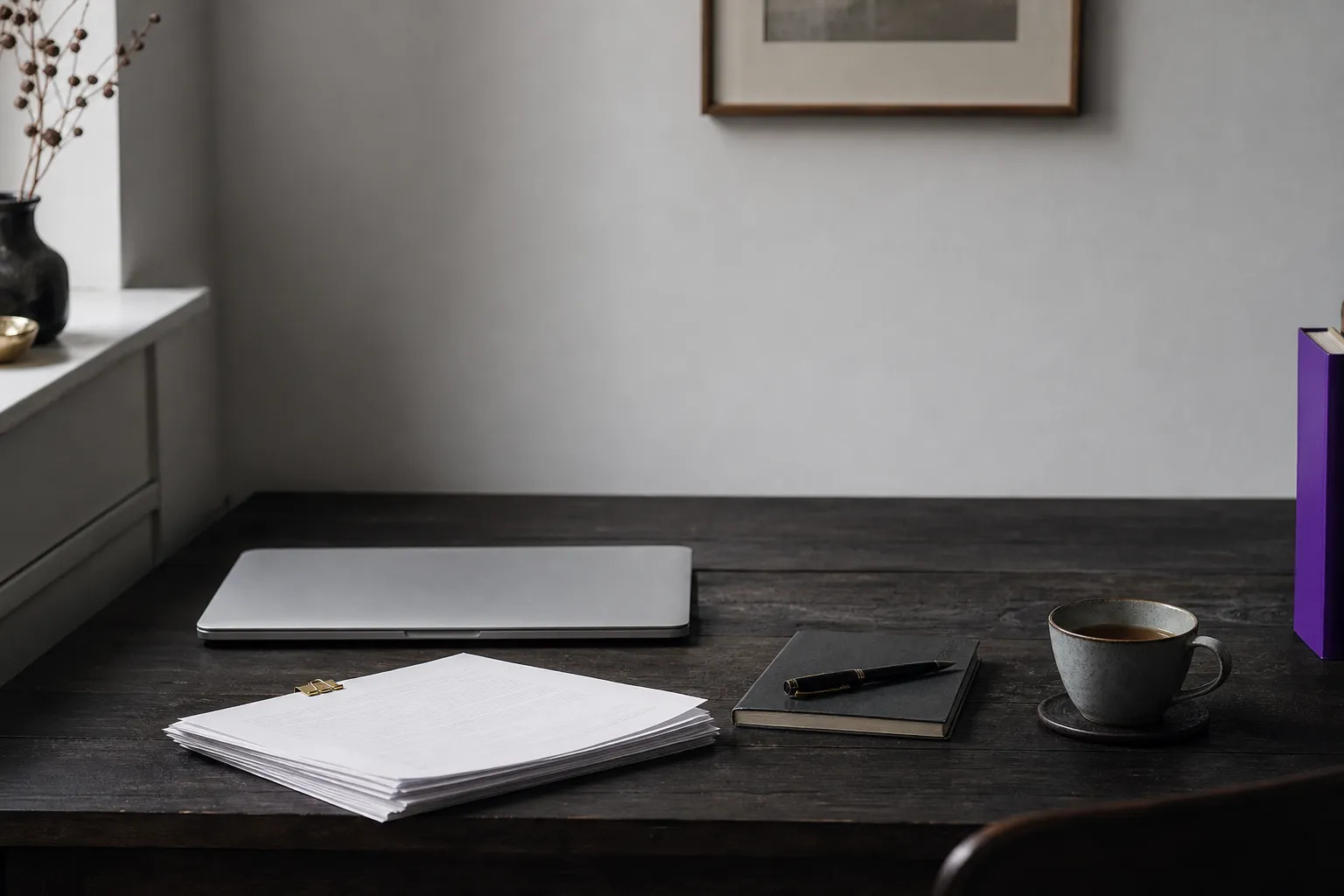 A quiet wooden desk with a closed laptop, printed pages and a fountain pen, used to illustrate a technical SEO audit.