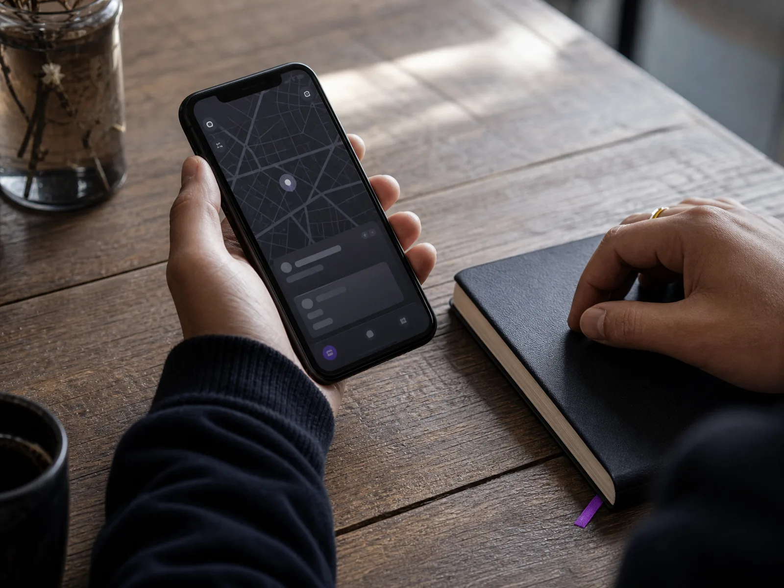 Close shot of a hand holding a phone displaying an abstract dark map interface, illustrating the local SEO self-search test.